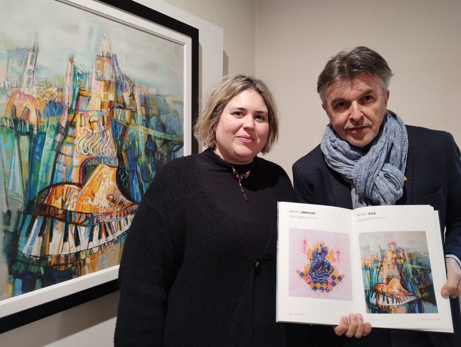 Patrizio Oca con il catalogo Cari Maestri aperto sulla pagina dedicata alla sua opera