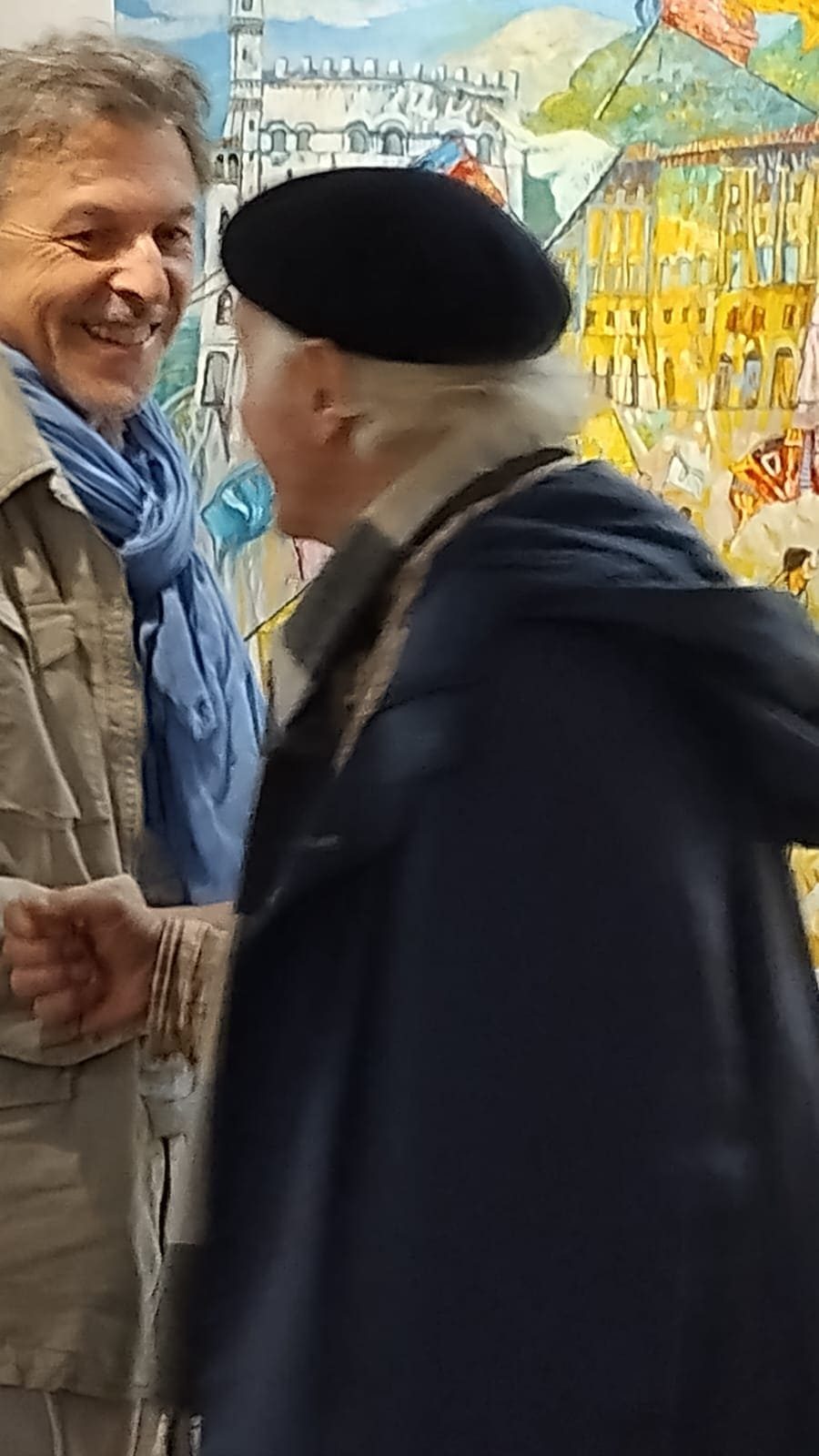L'artista dialoga con un ospite davanti alle opere