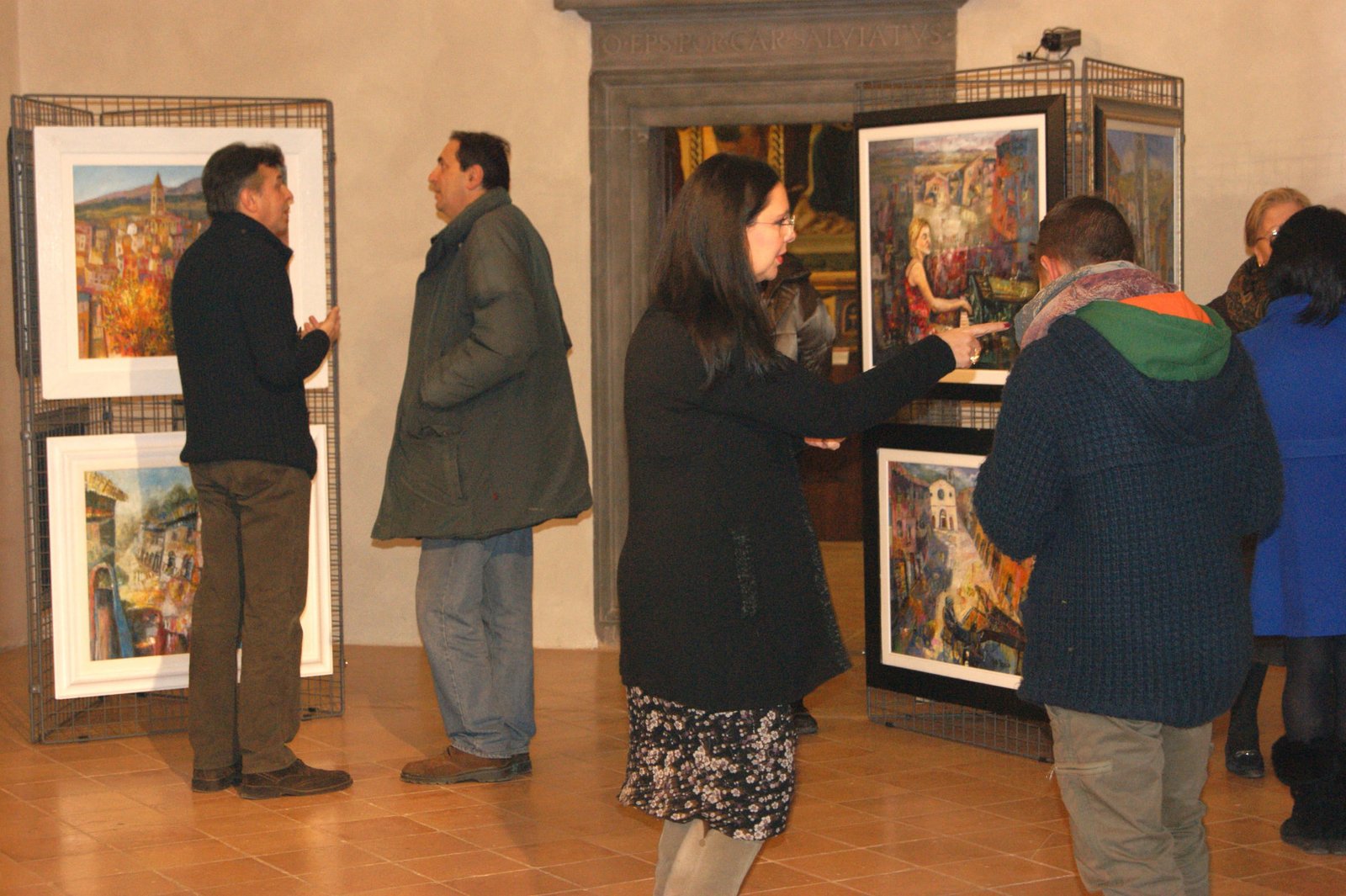 Visitatori ammirano le opere nella sala espositiva