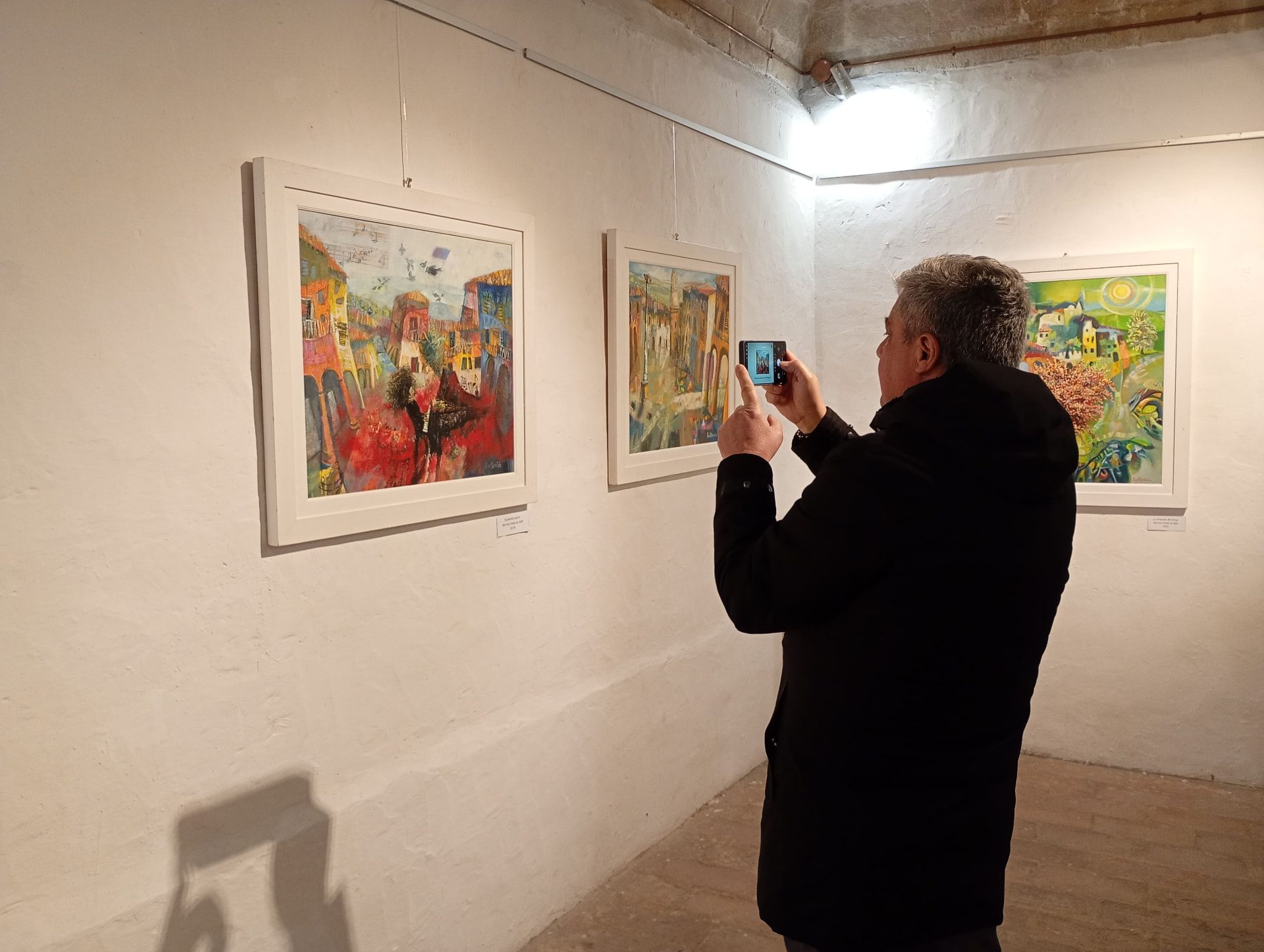 Un visitatore fotografa le opere in mostra