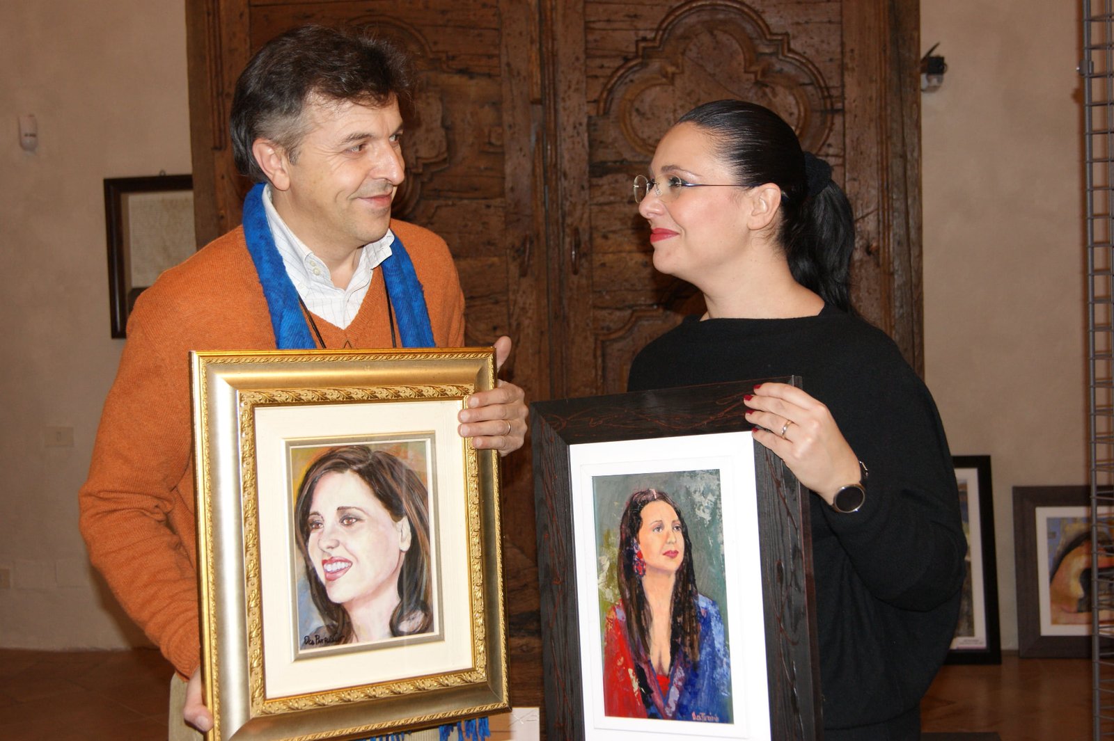 Patrizio Oca con i ritratti esposti in mostra