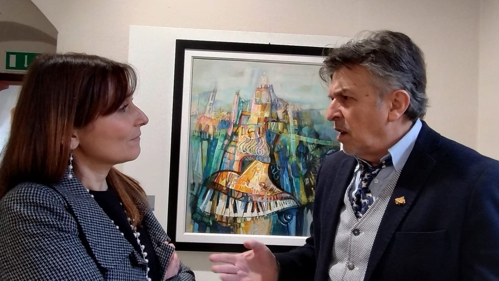 Patrizio Oca dialoga con una visitatrice davanti alla sua opera esposta