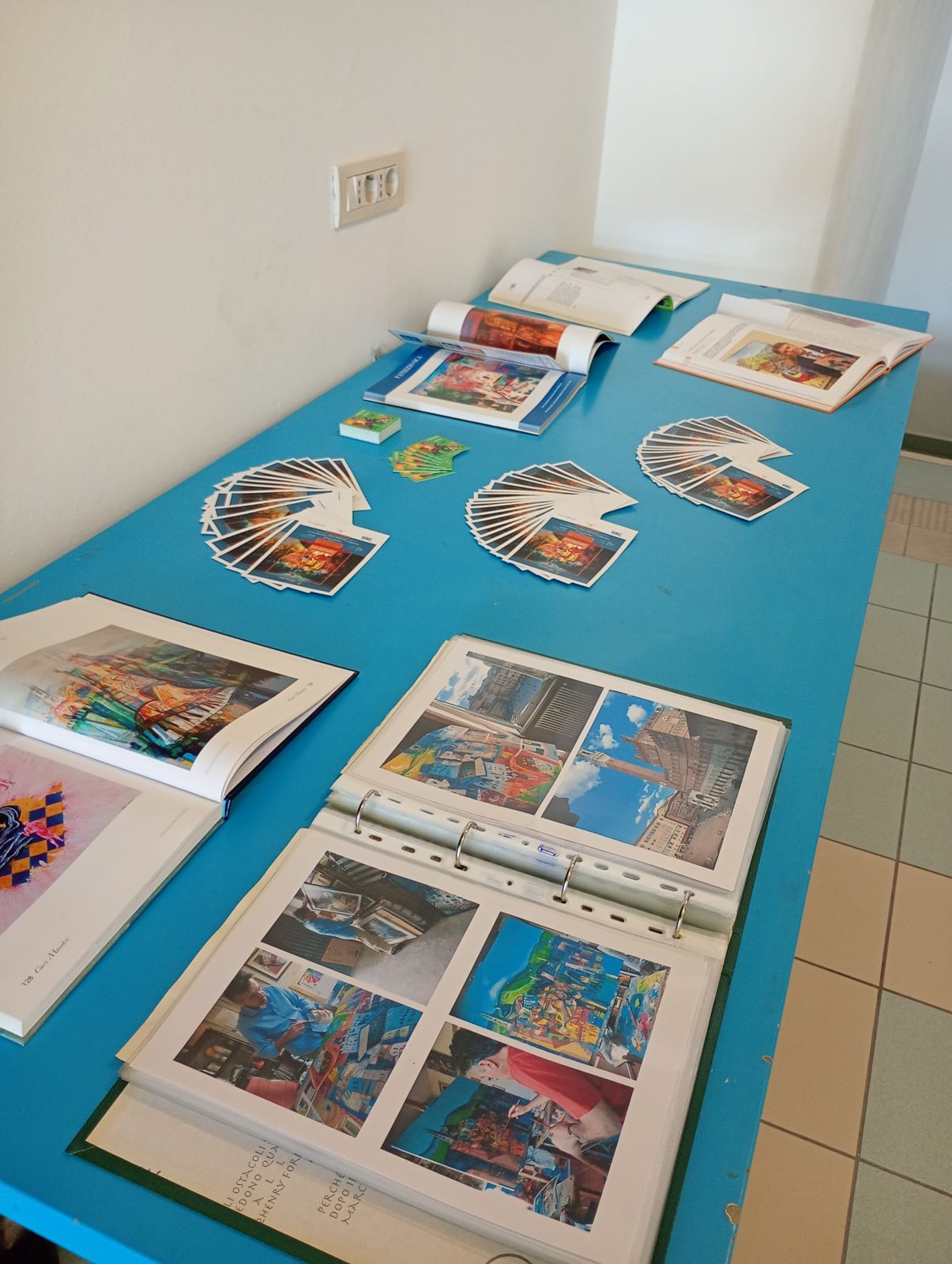 Il tavolo con cataloghi, cartoline e materiali della mostra