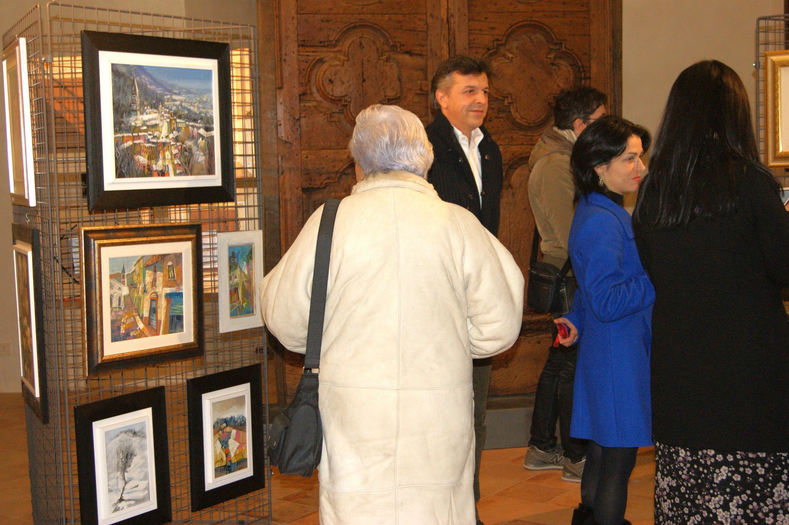 Visitatori osservano le opere esposte nella sala