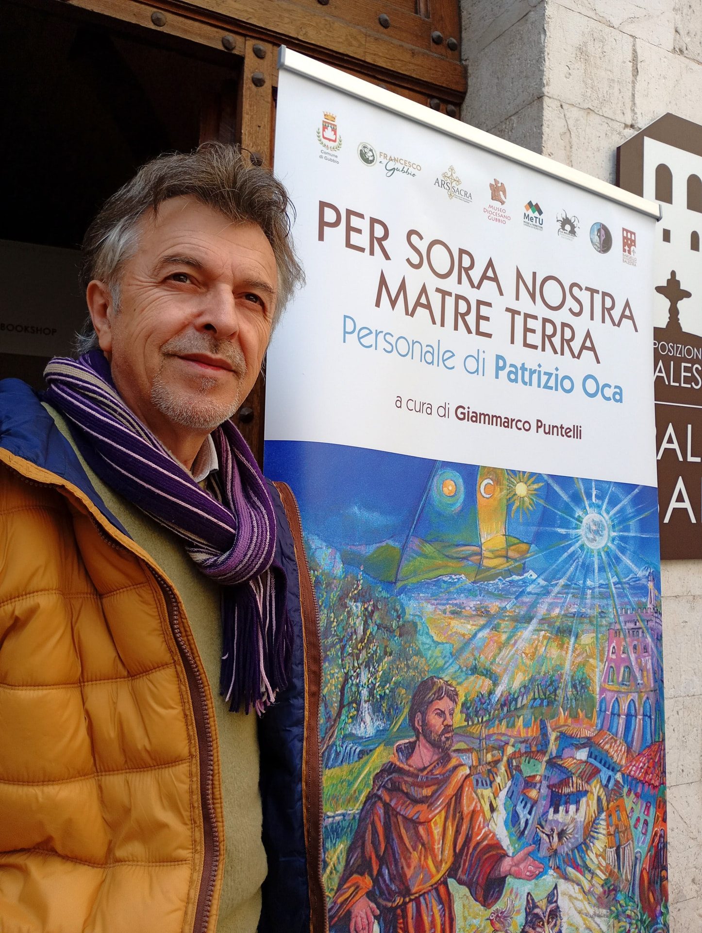 Patrizio Oca davanti all'opera San Francesco e madre natura