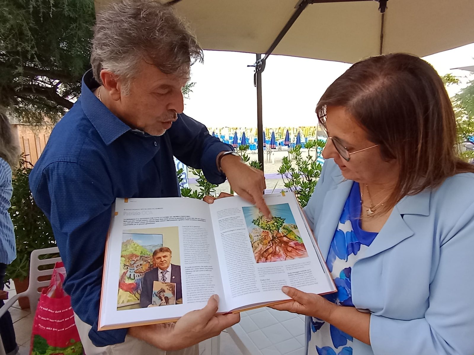 L'artista mostra le pagine del volume Profili d'artista a lui dedicate